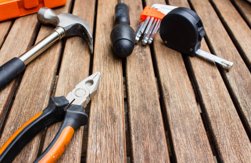 collection of handyman tools on a wooden board surface - SMI Handyman Leeds, Horsforth