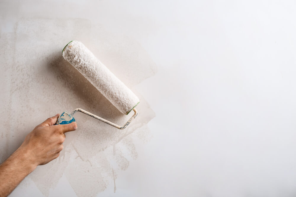 handyman painting wall using a roller with white paint - SMI Handyman Leeds, Horsforth